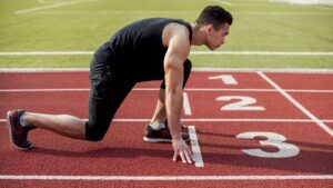 um homem na linha de largada de uma prova de atletismo